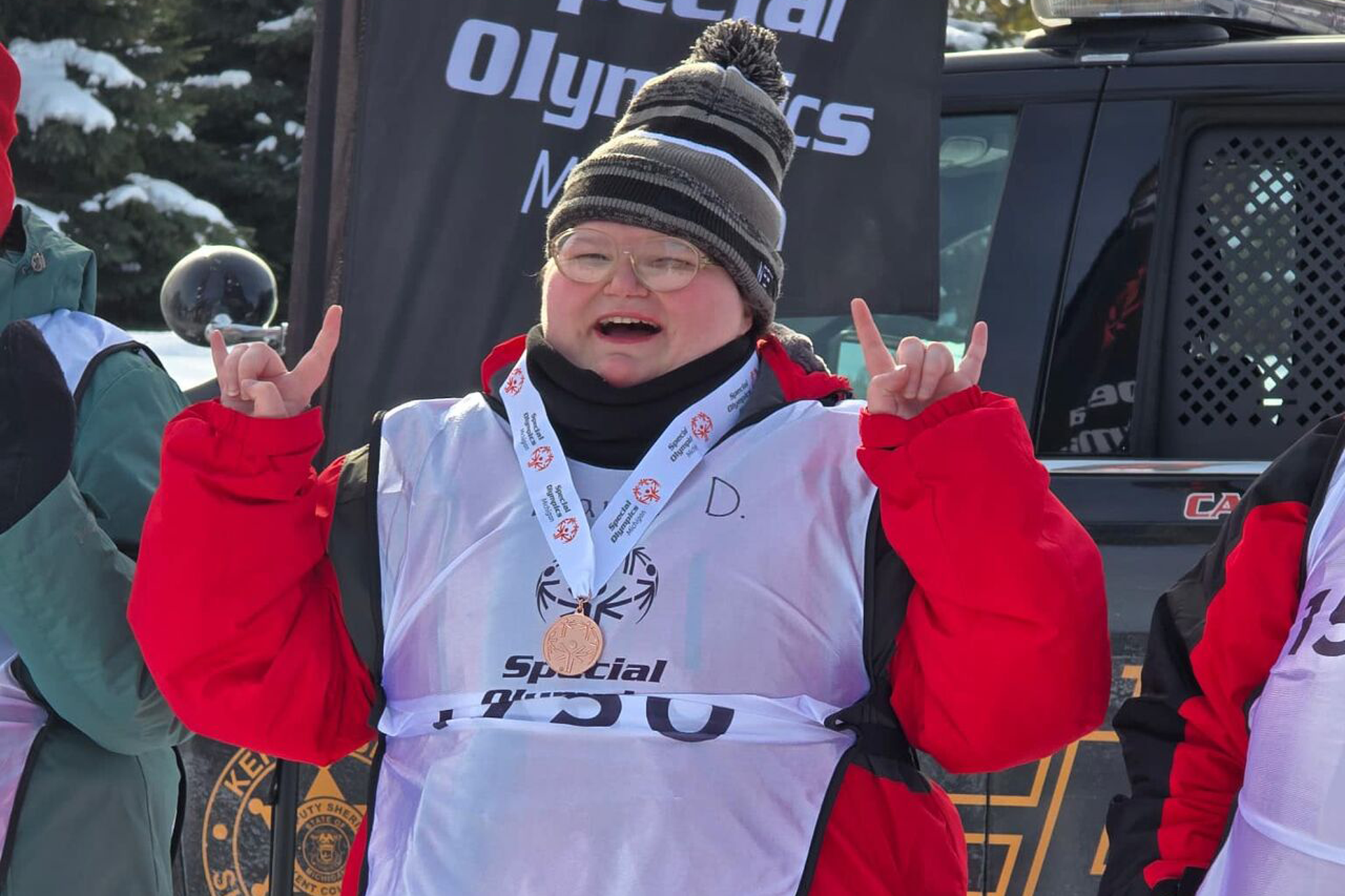 student smiling with a bronze medal